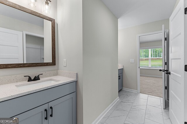 bathroom featuring vanity, baseboards, and marble finish floor