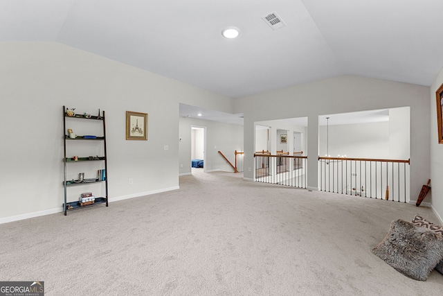 interior space with carpet floors, vaulted ceiling, and visible vents