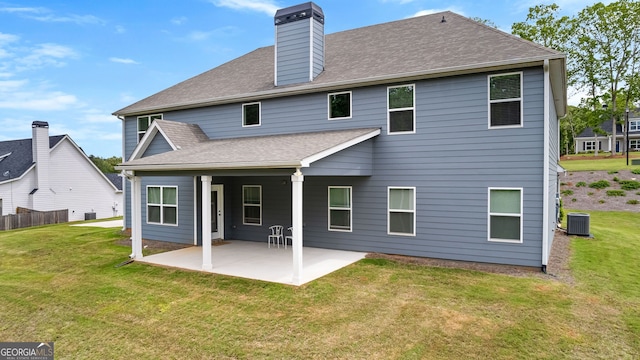 back of house with roof with shingles, a yard, central AC, and a patio area
