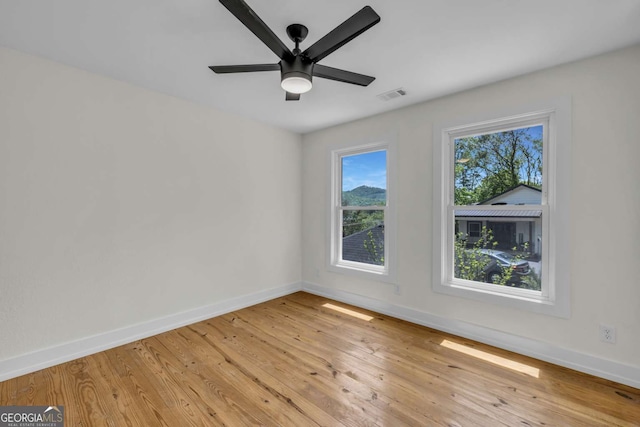 233 Bradshaw Rd, Hiawassee, GA 30546 - spare room featuring light wood-style floors, baseboards, ceiling fan, and visible vents