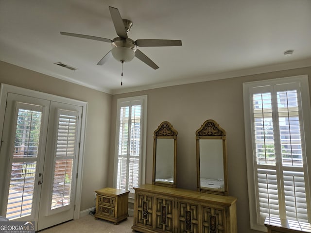 interior space featuring carpet flooring, ceiling fan, baseboards, visible vents, and ornamental molding