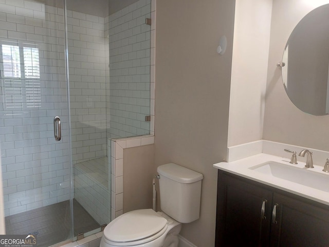 bathroom with vanity, a stall shower, and toilet