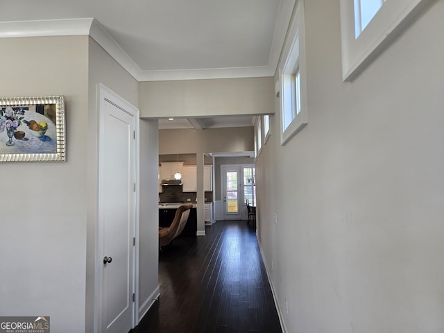 hallway featuring crown molding, dark wood-style flooring, and baseboards