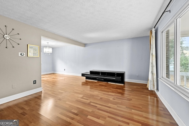 4608 Rosemear Ct, Norcross, GA 30093 - below grade area with a textured ceiling, an inviting chandelier, plenty of natural light, and light wood-type flooring