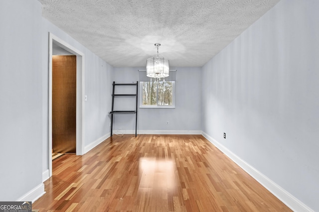 4608 Rosemear Ct, Norcross, GA 30093 - unfurnished dining area featuring an inviting chandelier, light wood-type flooring, and a textured ceiling