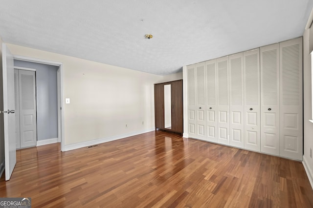 4608 Rosemear Ct, Norcross, GA 30093 - unfurnished bedroom featuring baseboards, wood finished floors, and visible vents