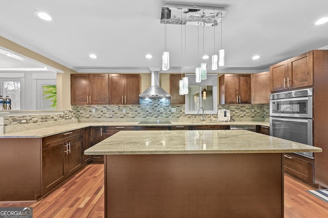 4608 Rosemear Ct, Norcross, GA 30093 - kitchen with tasteful backsplash, light wood-style flooring, a kitchen island, and wall chimney exhaust hood