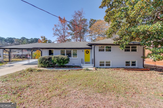 tri-level home with brick siding, a front lawn, driveway, and a carport