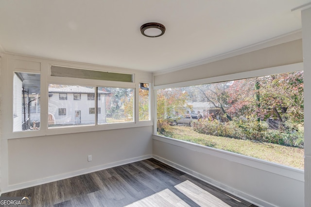 unfurnished sunroom with baseboards and wood finished floors