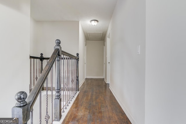 hallway with baseboards, attic access, wood finished floors, and an upstairs landing