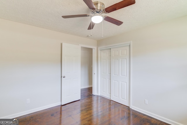 unfurnished bedroom featuring a textured ceiling, baseboards, and wood finished floors