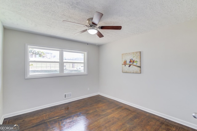 unfurnished room with a ceiling fan, a textured ceiling, visible vents, baseboards, and dark wood-style floors