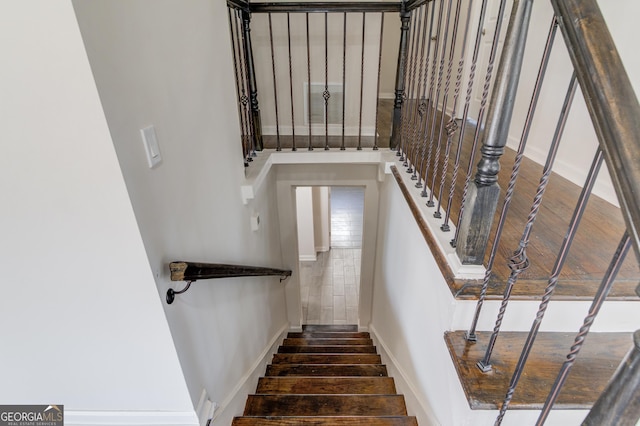 staircase with baseboards and wood finished floors
