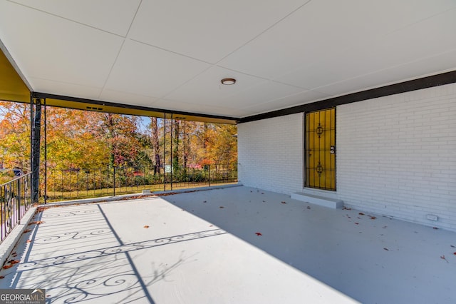 view of patio featuring fence and a carport