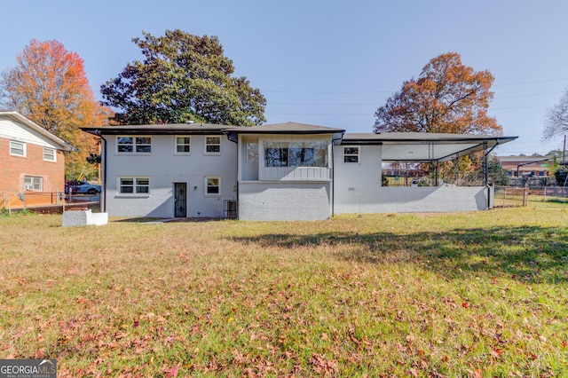 back of house featuring brick siding, a yard, fence, and board and batten siding