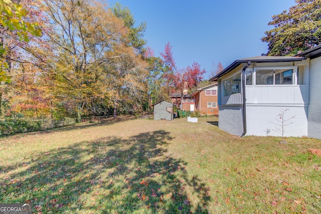 view of yard featuring fence, an outdoor structure, and a shed