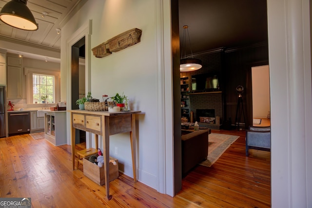 hall with crown molding and light wood-style flooring