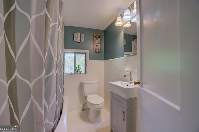 bathroom with wainscoting, vanity, toilet, tile walls, and a shower with curtain