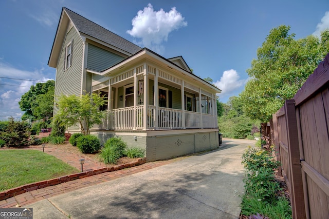 exterior space featuring a porch and a shingled roof