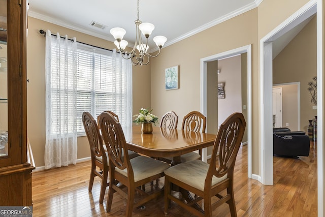 dining room featuring crown molding, a chandelier, visible vents, and plenty of natural light