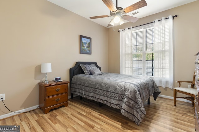 bedroom with baseboards, visible vents, multiple windows, and light wood-style floors