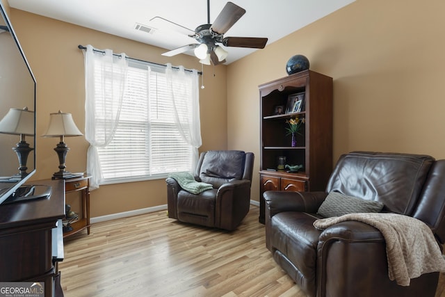 sitting room with a ceiling fan, baseboards, visible vents, and light wood finished floors