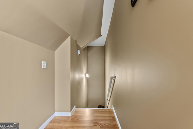 stairway with baseboards and wood finished floors