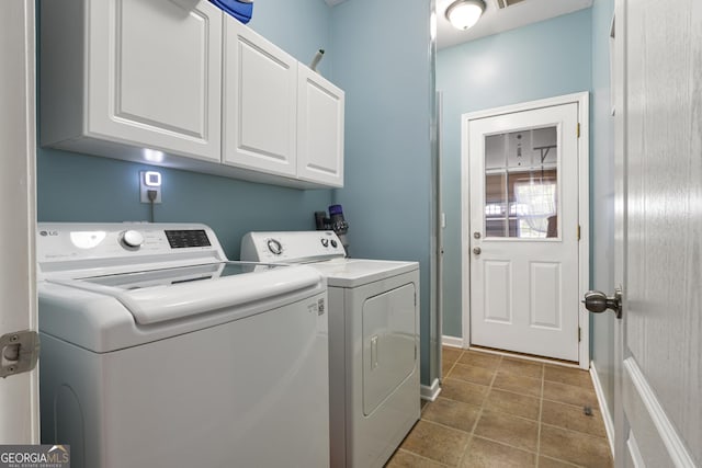 clothes washing area featuring baseboards, tile patterned flooring, cabinet space, and washer and clothes dryer