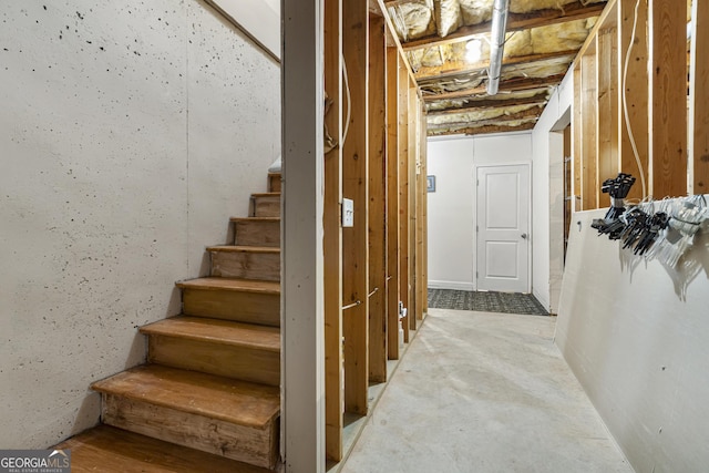 stairway featuring unfinished concrete floors