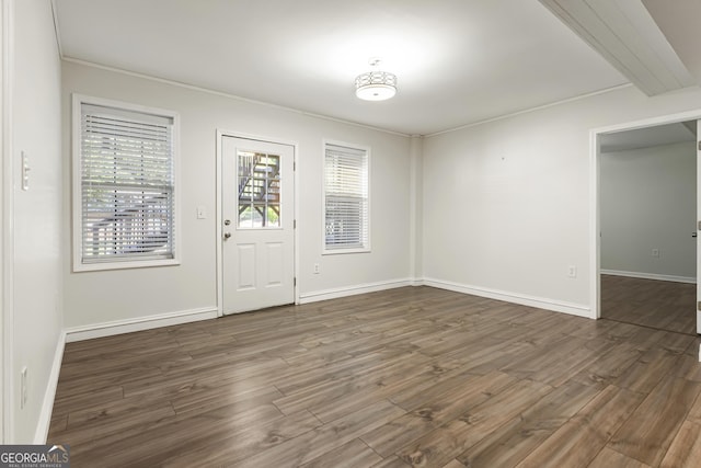 entryway featuring baseboards, dark wood finished floors, and ornamental molding
