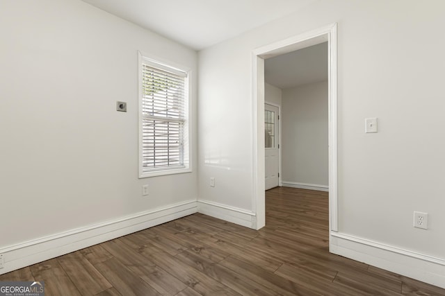 unfurnished room with baseboards, a baseboard radiator, and wood finished floors