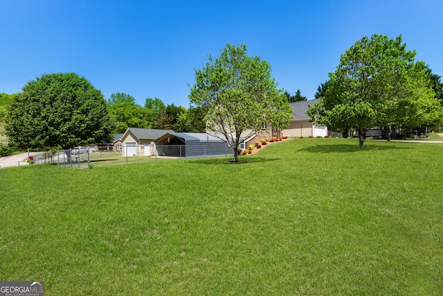 view of yard featuring fence and a carport