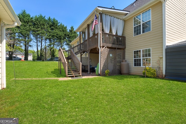 back of house featuring a lawn, stairs, and a deck