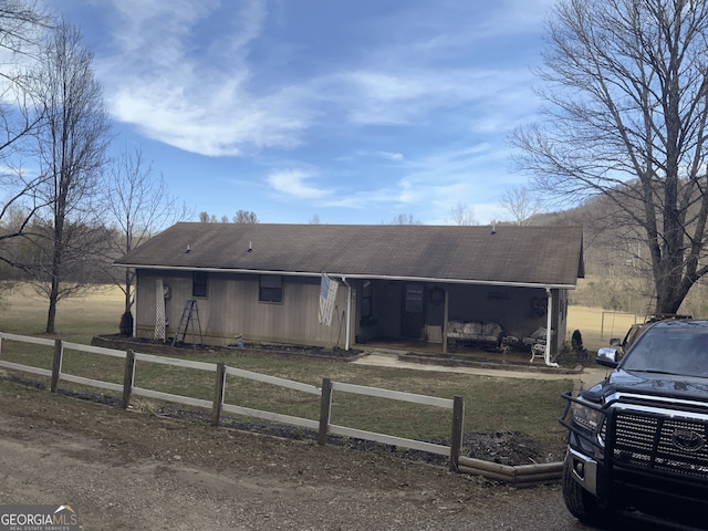 view of front of property with a porch, a fenced front yard, and a shingled roof