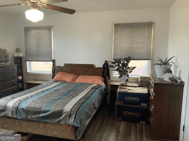 bedroom with ceiling fan, multiple windows, and wood finished floors