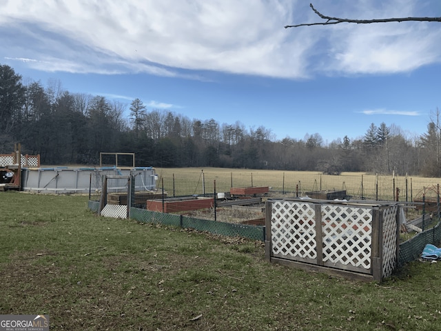 view of yard featuring a garden and an outdoor pool