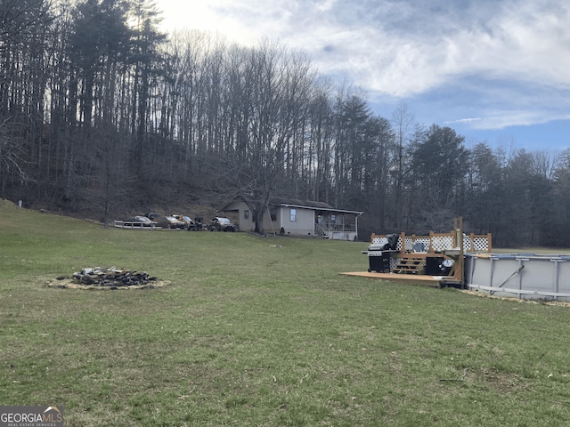 view of yard with an outdoor pool and a wooden deck