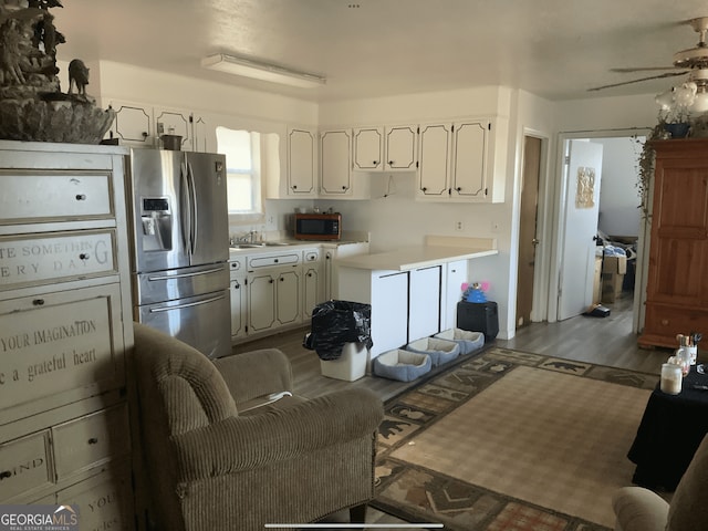kitchen with ceiling fan, wood finished floors, light countertops, white cabinets, and stainless steel appliances
