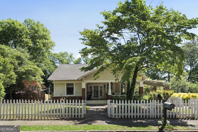 view of front facade featuring a fenced front yard and french doors