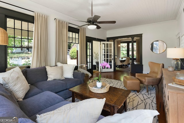living area featuring wood finished floors, a ceiling fan, ornamental molding, and french doors