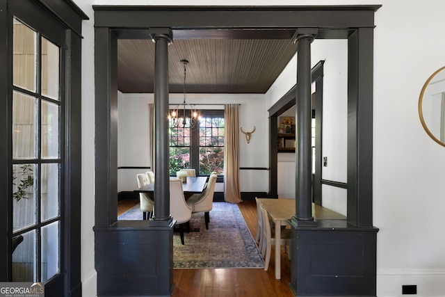 corridor featuring dark wood-style floors, a chandelier, and baseboards