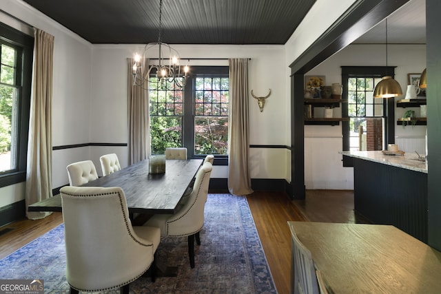 dining area with a chandelier, dark wood-type flooring, and baseboards