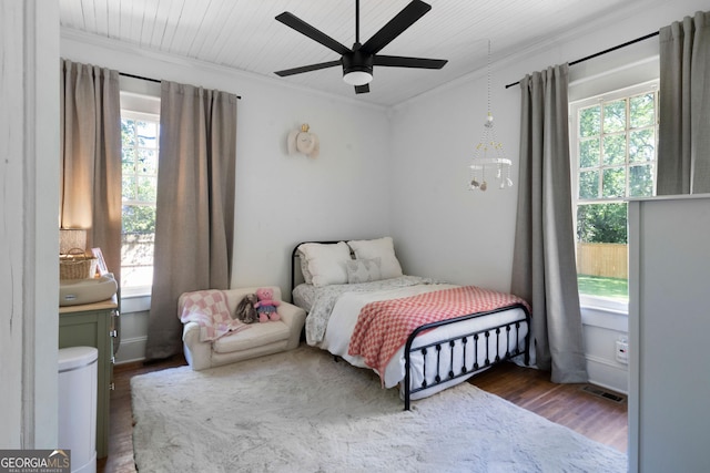 bedroom with ornamental molding, wood finished floors, and a ceiling fan
