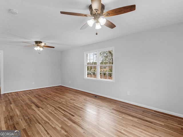 empty room featuring baseboards, a ceiling fan, and wood finished floors