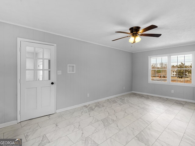unfurnished room with baseboards, a ceiling fan, marble finish floor, and ornamental molding