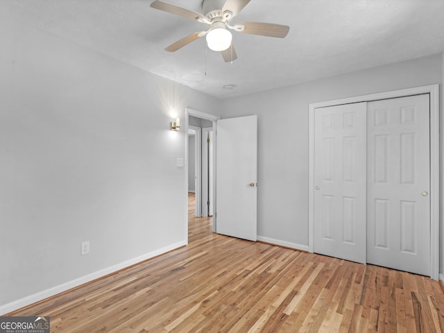 unfurnished bedroom with baseboards, a ceiling fan, light wood finished floors, and a closet