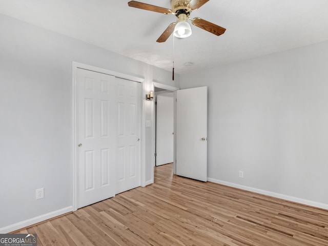 unfurnished bedroom with light wood-type flooring, baseboards, ceiling fan, and a closet