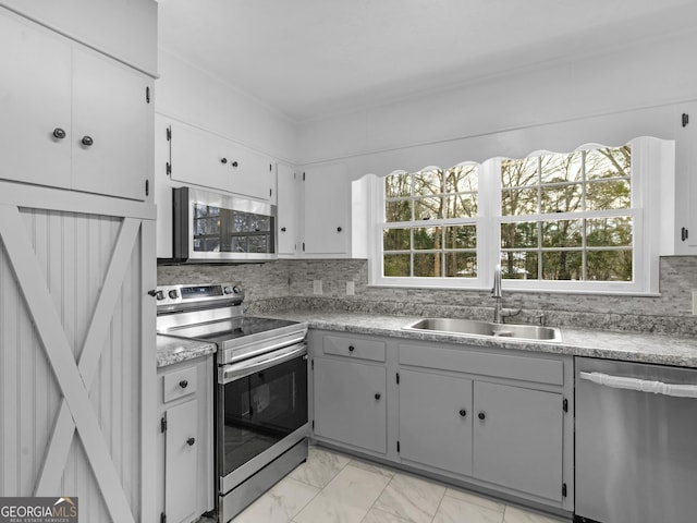 kitchen with stainless steel appliances, plenty of natural light, a sink, and marble finish floor
