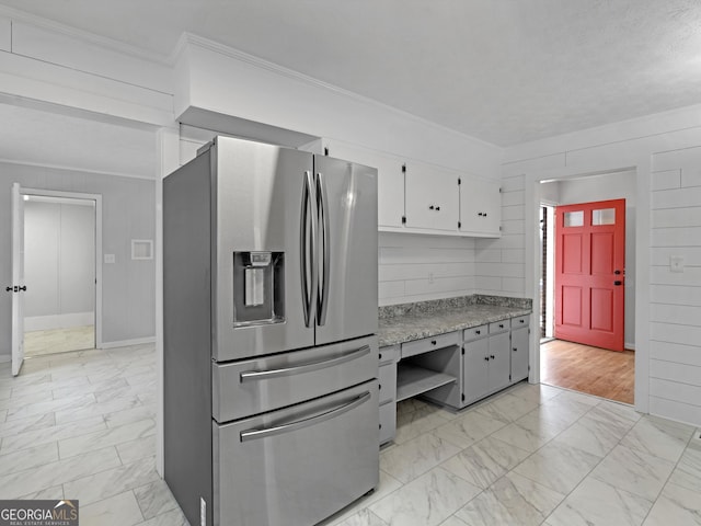 kitchen featuring light countertops, stainless steel fridge with ice dispenser, marble finish floor, ornamental molding, and white cabinetry