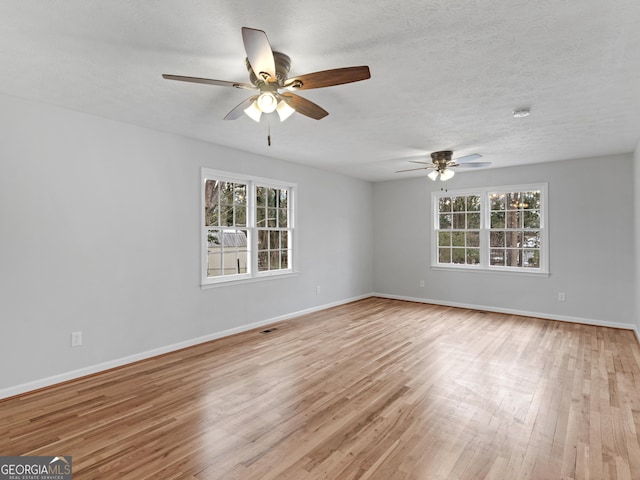unfurnished room with baseboards, a ceiling fan, and light wood-style flooring